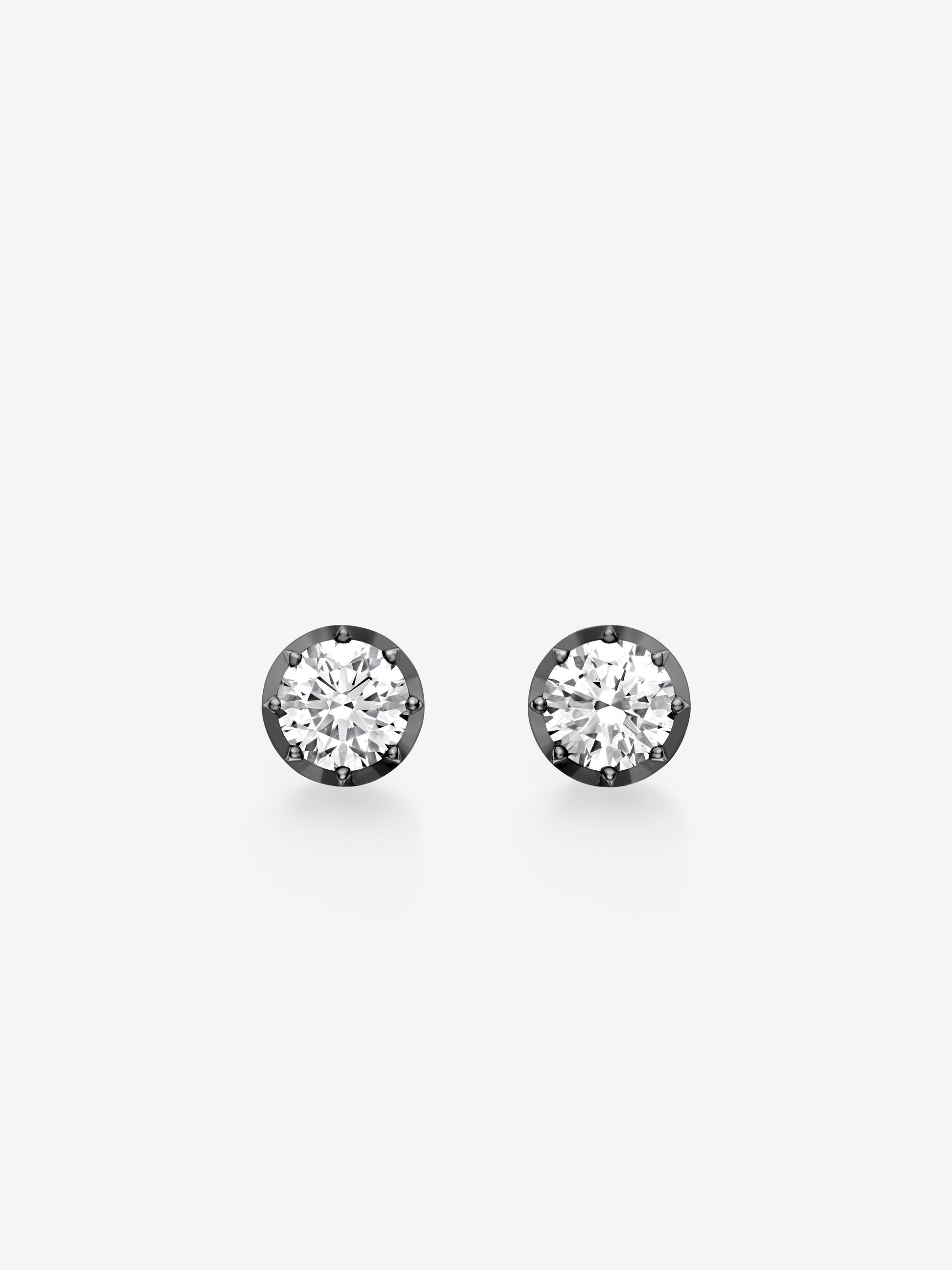 Pair of round brilliant-cut diamonds set in blackened gold stud earrings showcasing Jessica McCormack’s blend of antique-inspired craftsmanship and contemporary elegance. View 1