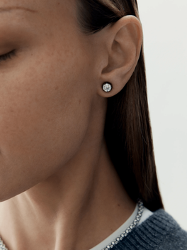 Close-up of a woman's ear wearing a contemporary 1ct diamond stud earring set in blackened gold, reflecting Jessica McCormack’s blend of antique craftsmanship and modern design.