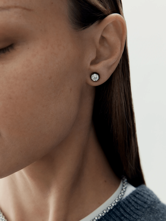 Close-up of a woman's ear wearing a contemporary 1ct diamond stud earring set in blackened gold, reflecting Jessica McCormack’s blend of antique craftsmanship and modern design. View 3