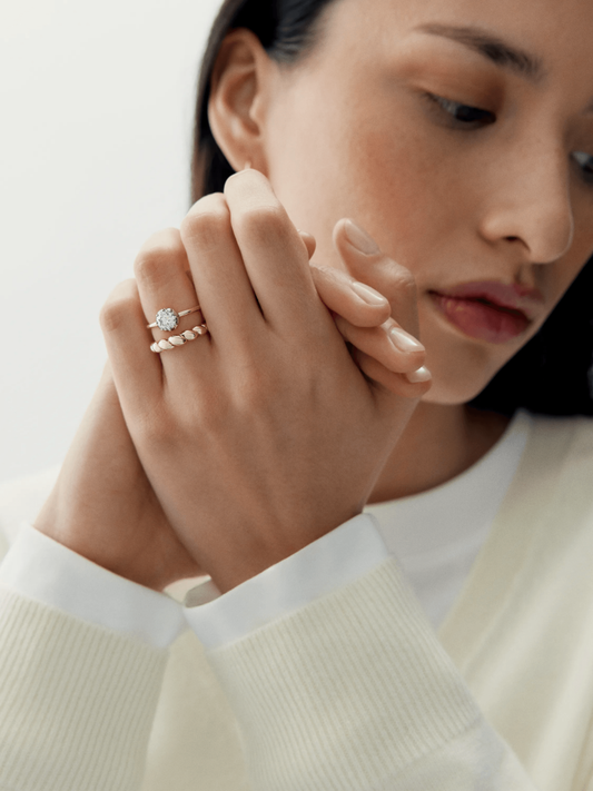 Close-up of a woman wearing an elegant diamond and white gold ring crafted with traditional techniques, showcasing a contemporary yet antique-inspired design. View 3