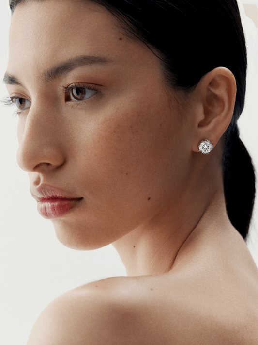 Close-up of a woman wearing a 3ct diamond stud earring set in white gold, showcasing timeless craftsmanship with a modern, antique-inspired design. View 3