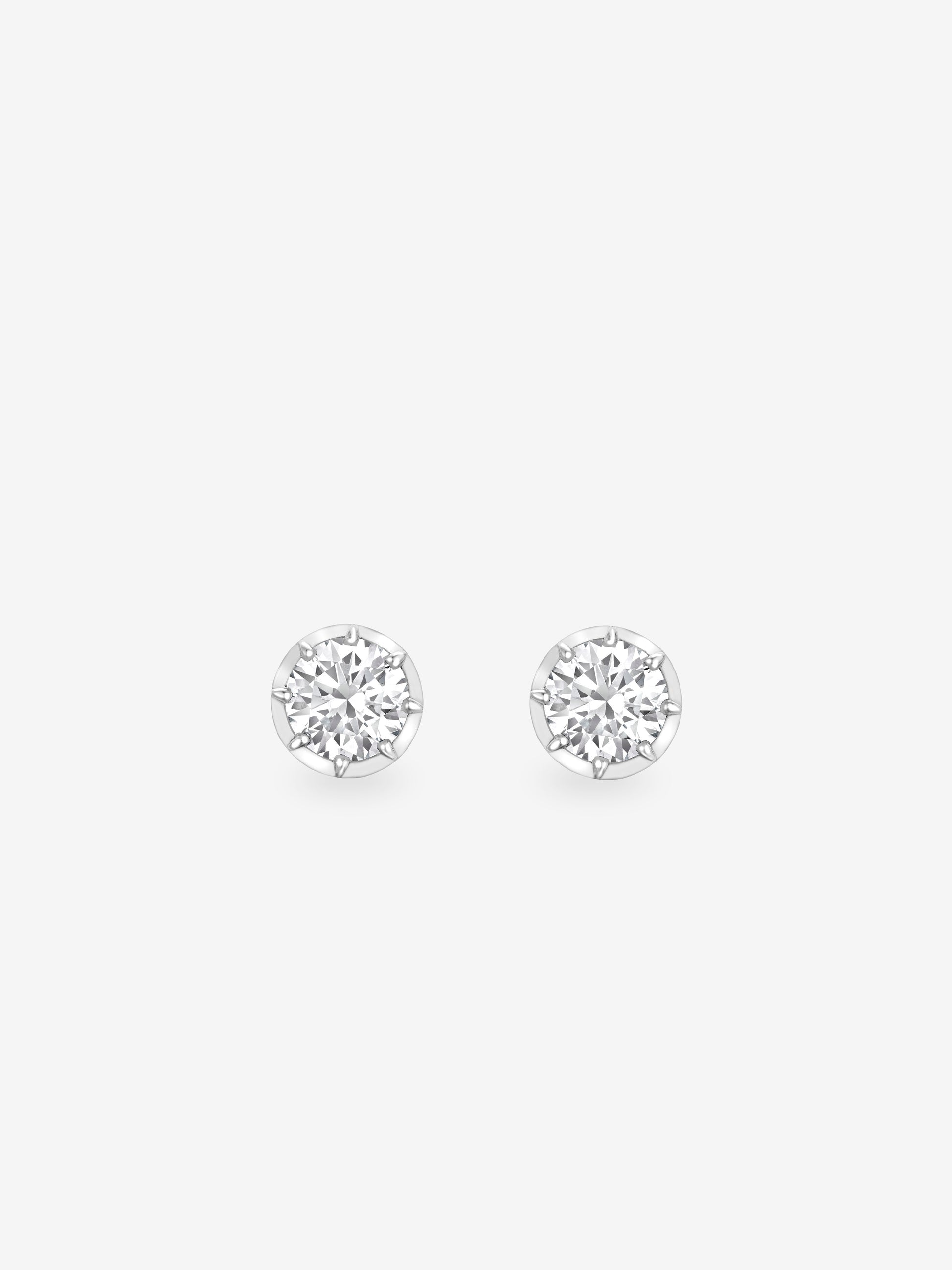 Pair of round brilliant cut diamond stud earrings set in white gold, showcasing timeless craftsmanship with a contemporary, antique-inspired design. View 1