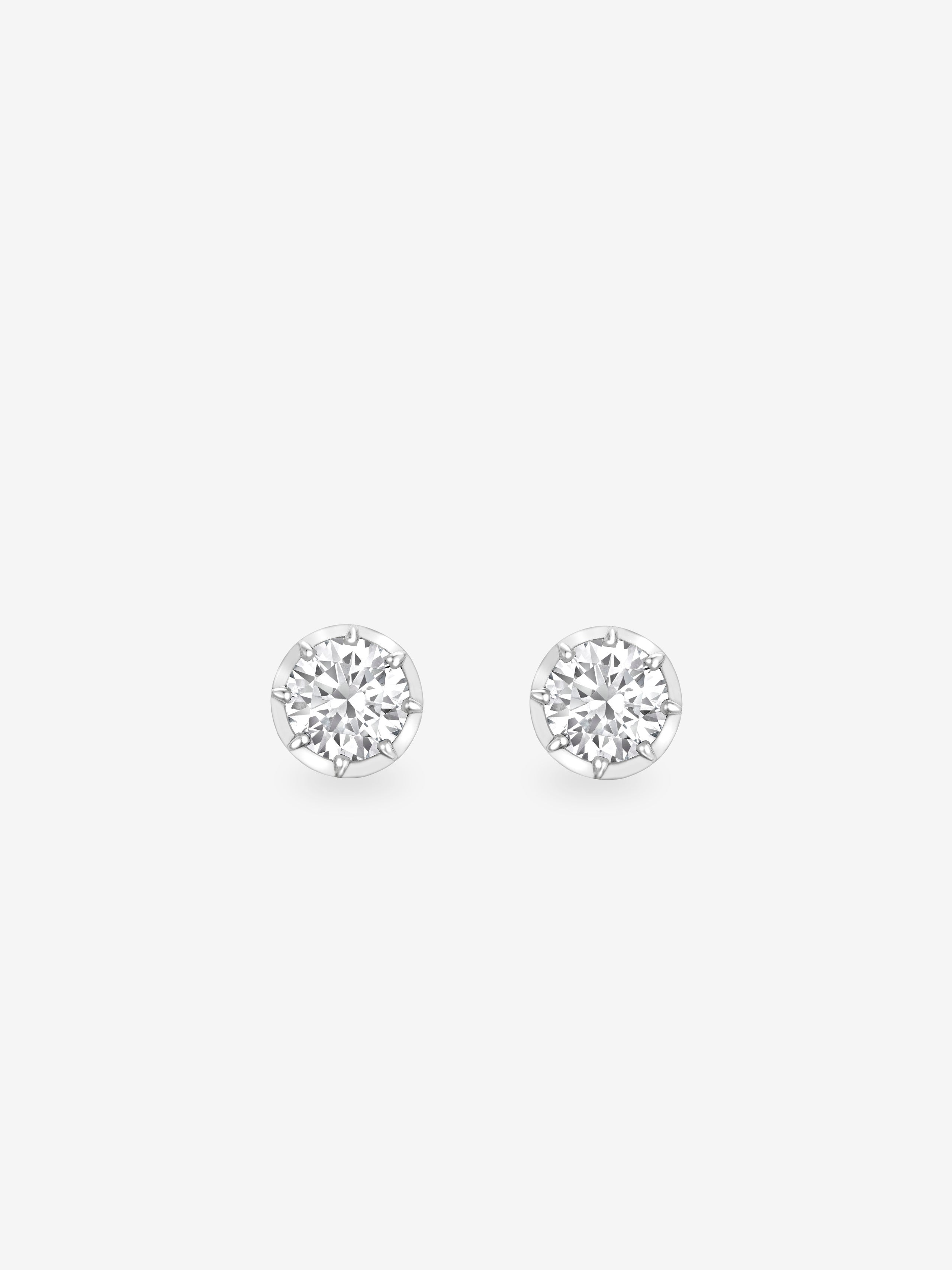 Pair of round brilliant cut diamond stud earrings set in white gold, showcasing timeless craftsmanship with a contemporary, antique-inspired design. View 1