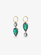 Asymmetric gold hoop earrings with pear shaped emeralds, round diamonds and dark contrasting settings, showcasing contemporary gypset craftsmanship
