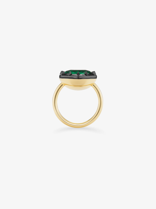 Side view of a heart-shaped emerald ring with a green gemstone in a dark button back setting and polished yellow gold band. View 4