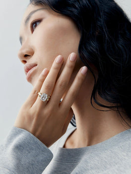 Model wearing a cushion cut diamond ring with an intricate bow inspired setting, showcasing contemporary style and fine jewellery craftsmanship.