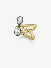 Jessica McCormack ring featuring two pear shaped diamonds in contrasting blackened gold settings above intertwined polished gold bands