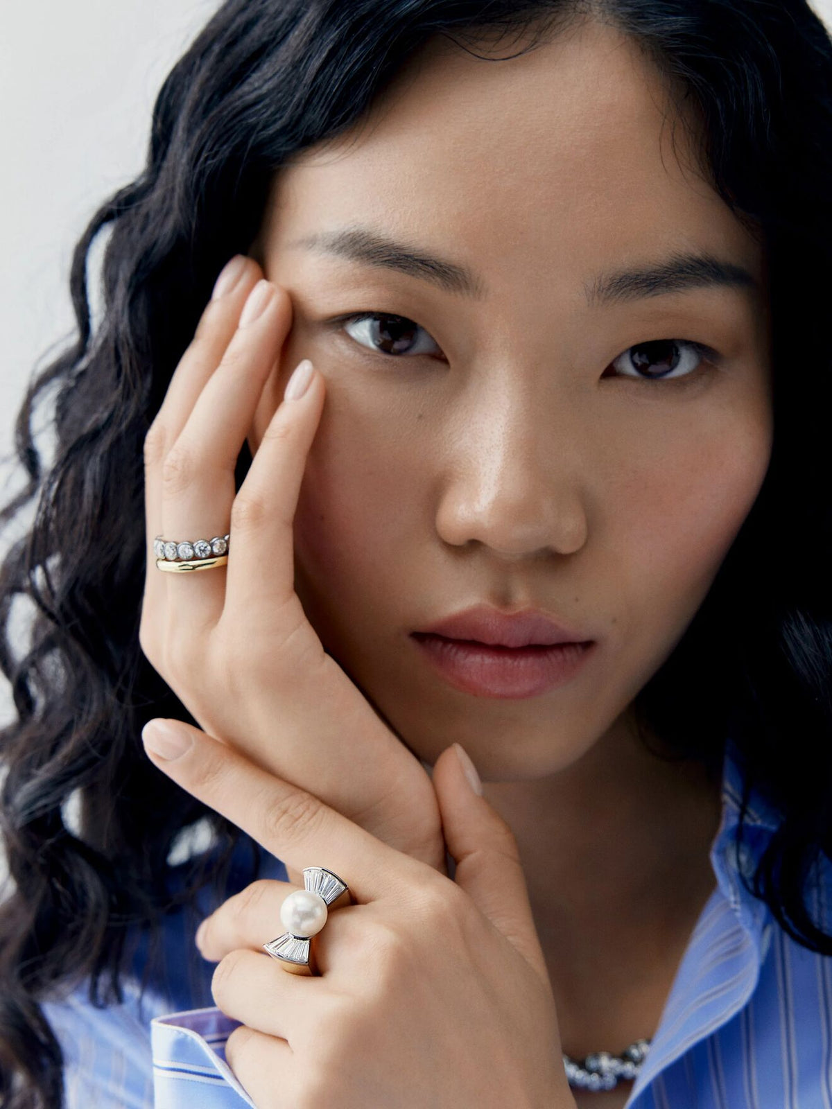 Close up portrait of a woman wearing a pearl and diamond ring with bow inspired shoulders, showcasing contemporary jewellery craftsmanship View 3