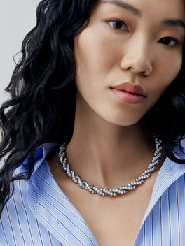 Model wearing a diamond and blackened gold ribbon necklace with a sculptural, antique-inspired design by Jessica McCormack
