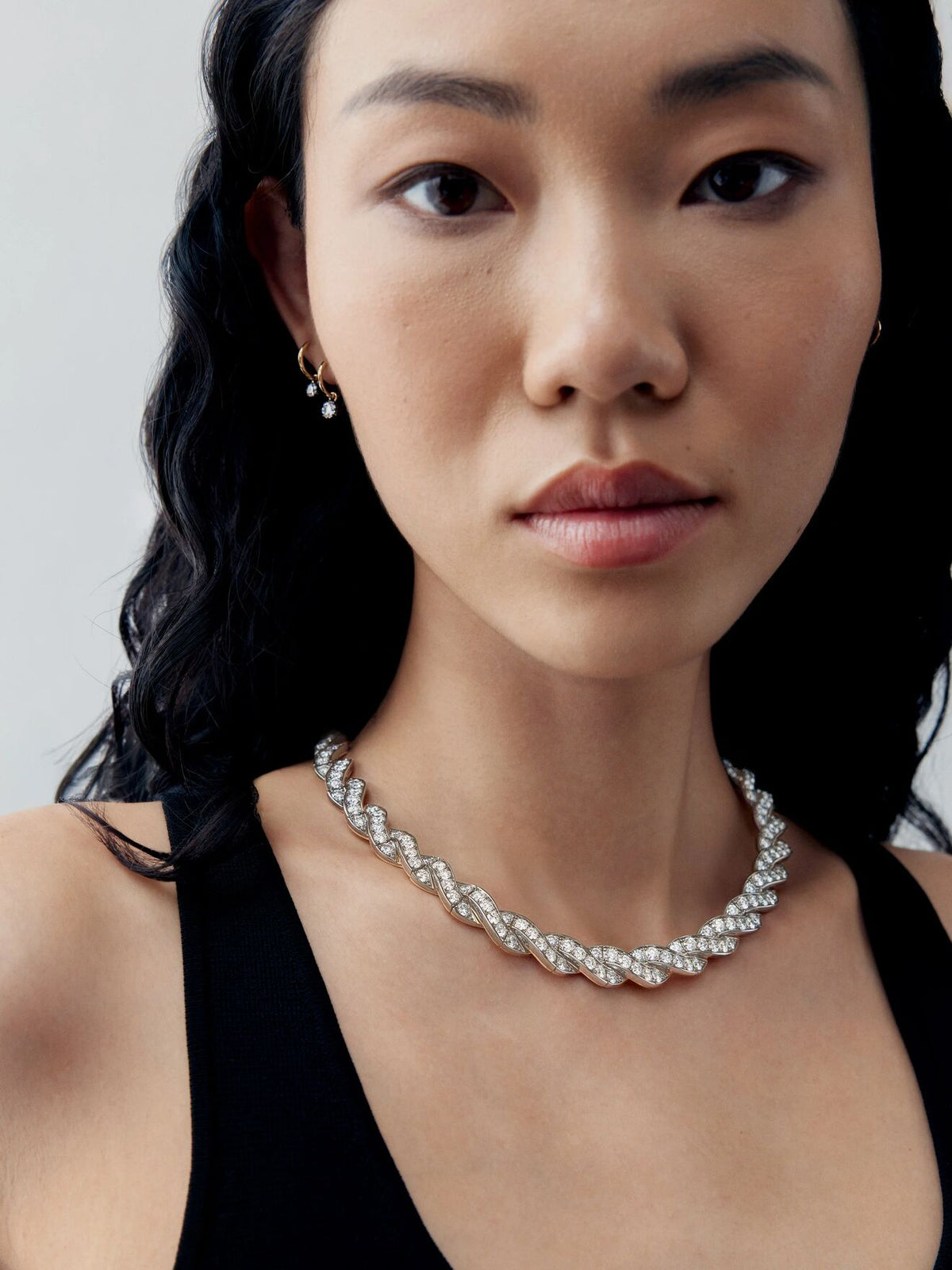 Jessica McCormack diamond ribbon necklace in white gold, styled on a model in a black dress with an intricate bow inspired design View 3