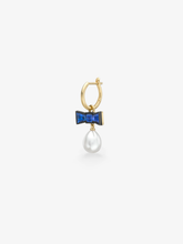 Gold hoop earring with a blue sapphire bow detail and a lustrous pearl drop, showcasing playful contemporary jewellery design