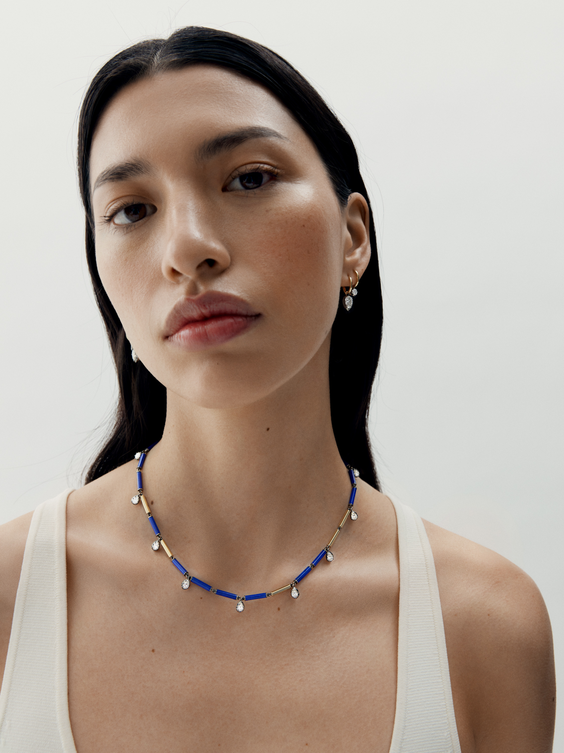 Woman wearing a blue beaded necklace against a plain background View 3