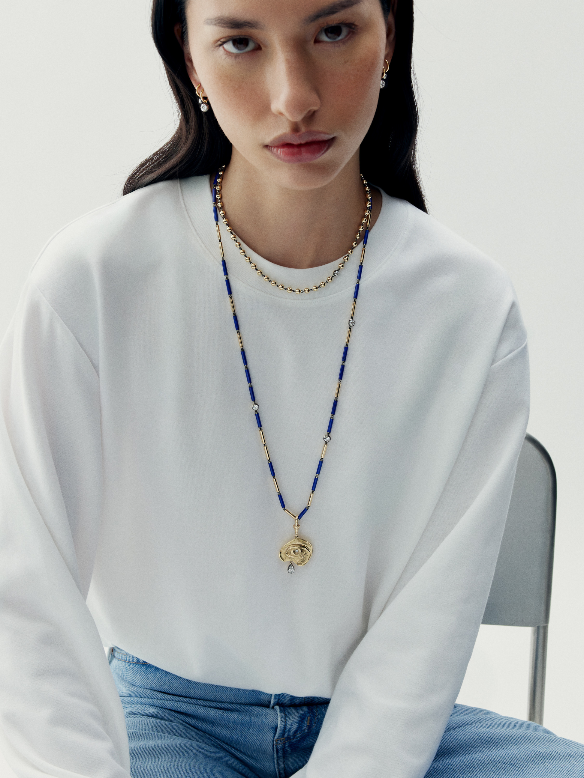 Woman wearing gold pendant with lapis lazuli chain View 3