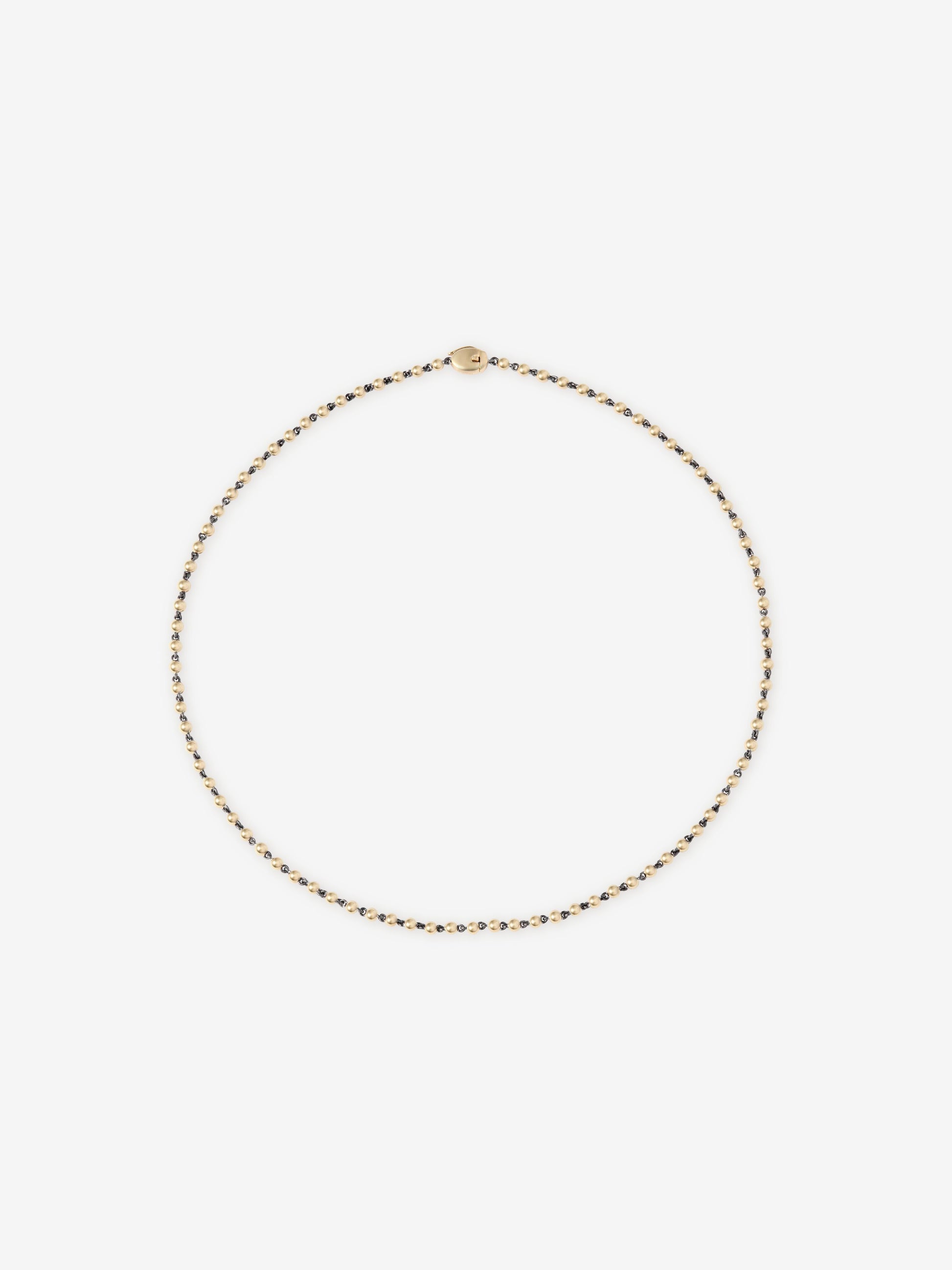 Delicate yellow gold micro ball and chain necklace with a smooth clasp, showcasing fine craftsmanship and a minimalistic, contemporary design. View 1