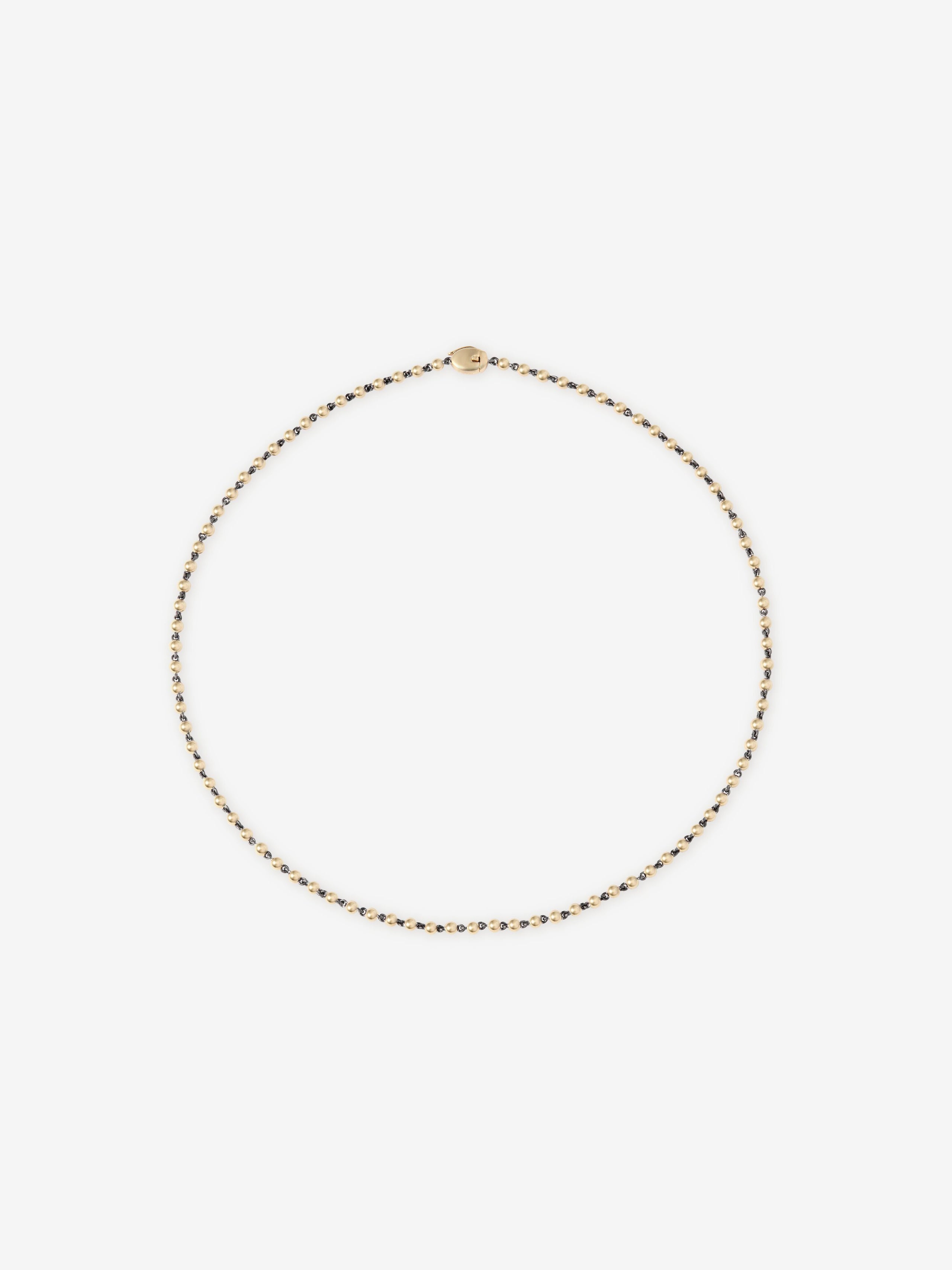 Delicate yellow gold micro ball and chain necklace with a smooth clasp, showcasing fine craftsmanship and a minimalistic, contemporary design. View 1