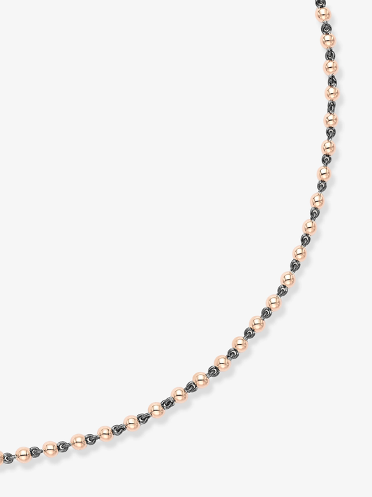 Close-up of a handcrafted micro ball and chain necklace in rose gold, showcasing intricate antique-inspired blackened links and contemporary design. View 2