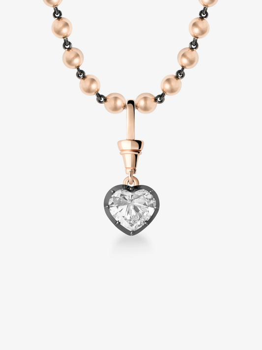 Heart-shaped diamond pendant set in a blackened gold bezel hanging from a rose gold ball chain necklace, blending antique-inspired craftsmanship with contemporary design. View 2