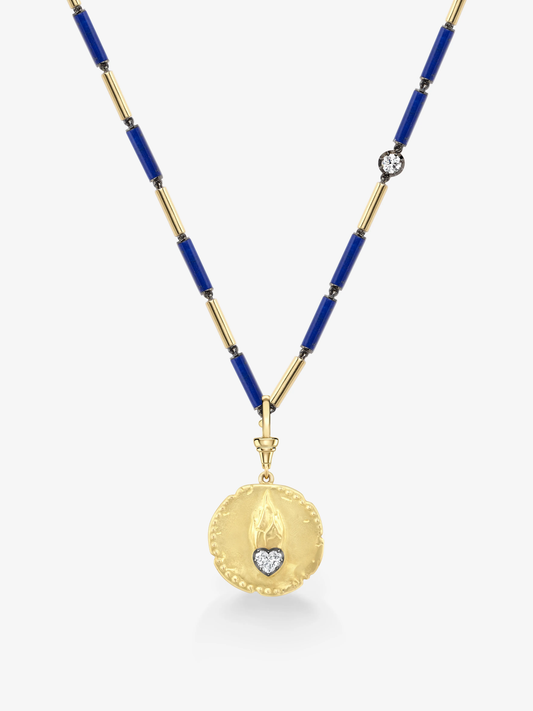 Round gold pendant with hand-engraved heart and flame motif featuring a small diamond, suspended on a necklace of alternating blue and gold cylindrical links with an additional small diamond detail. View 2