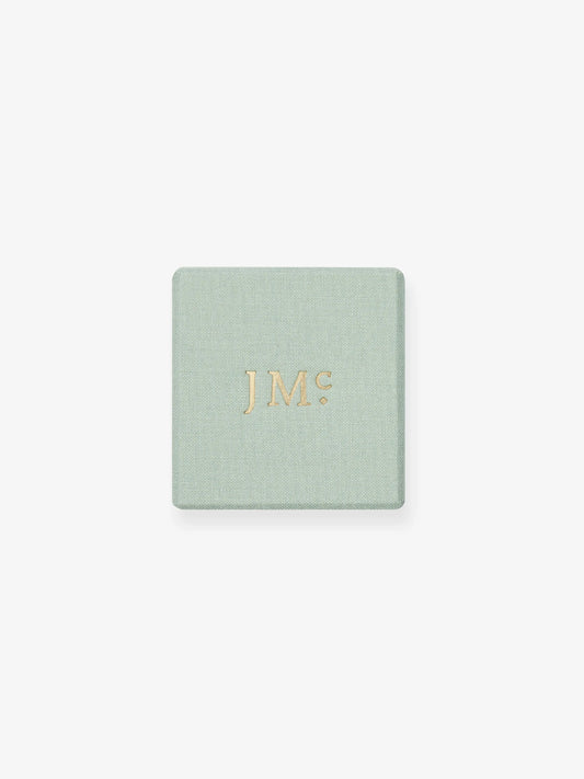 Light green textured jewelry box with gold embossed "JMC" logo, reflecting the refined craftsmanship and contemporary elegance of Jessica McCormack. View 5